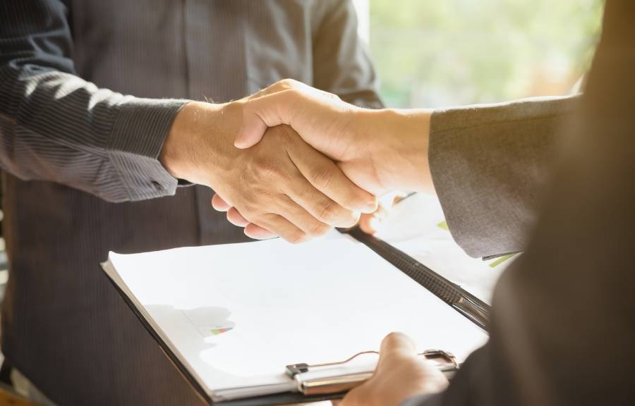 Handshake between a pest control technician and homeowner over a service agreement in Conroe, TX